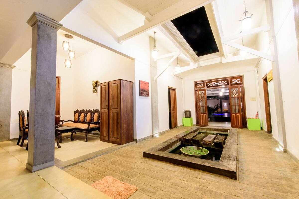 A spacious lobby with a fountain, wooden furniture, and a high ceiling with exposed beams.