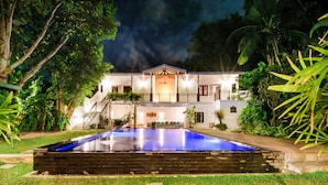 A two-story house with a swimming pool, surrounded by lush greenery. - Ali Gedara Bungalow (Galle)