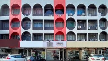 A multi-story building with a distinctive facade featuring large circular windows and a red and white color scheme.