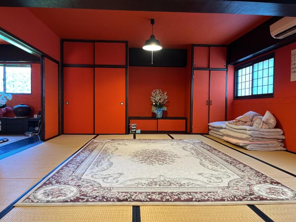 Una stanza con tatami, un tappeto grande, una lampada a sospensione e una finestra con vista.