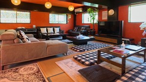 A modern living room with a sofa, coffee table, and television. - Airport Osaka (Kaizuka)
