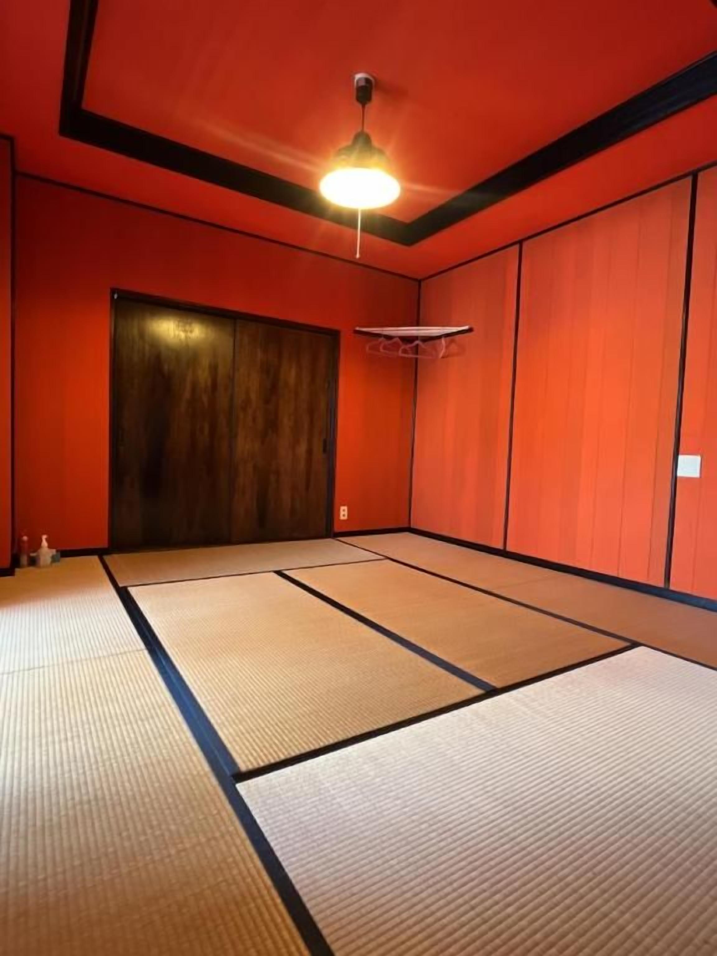 A room with tatami flooring, a ceiling fan, and a wooden door.