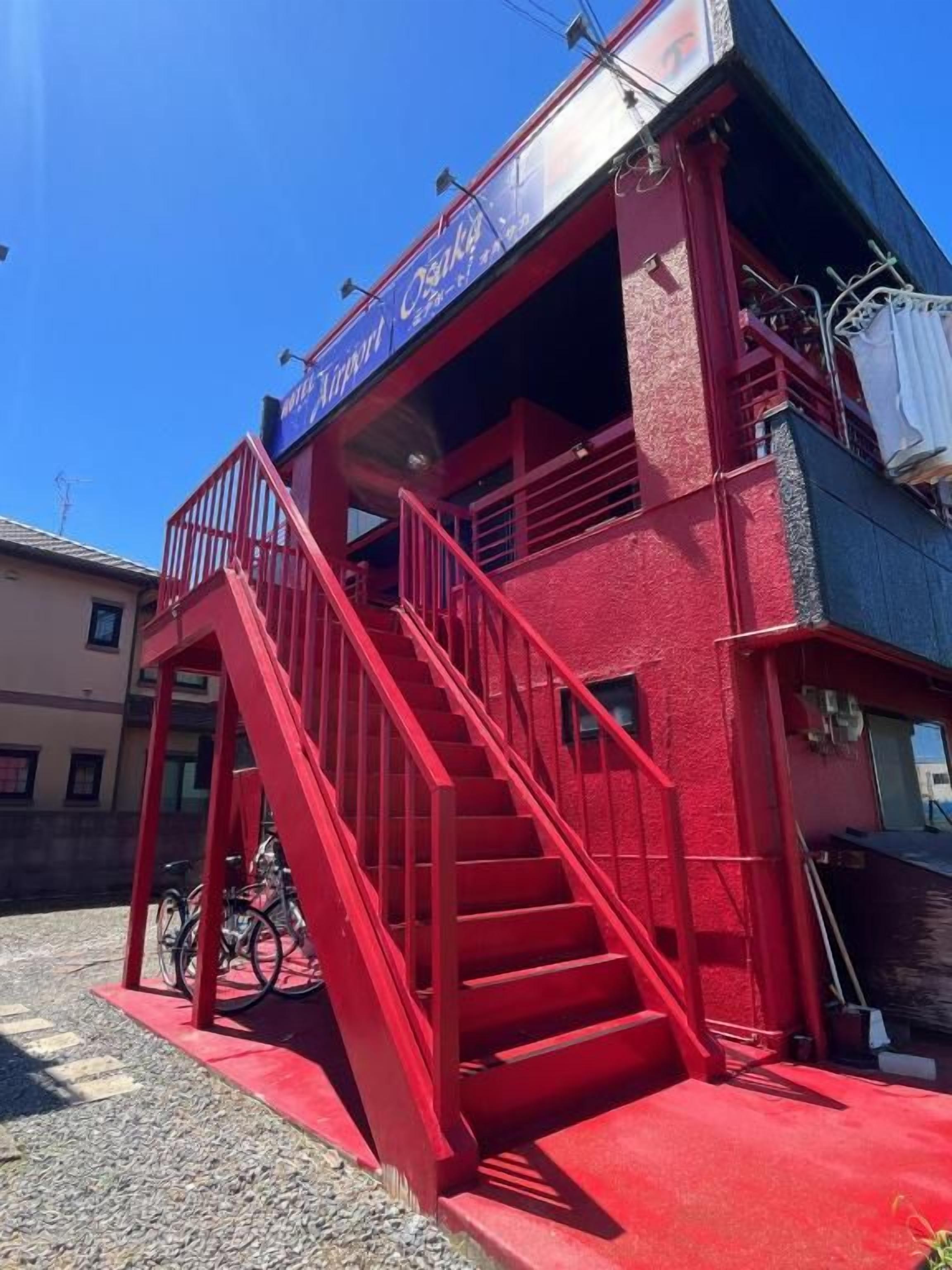 Um edifício vermelho com uma escadaria que leva a um andar superior.
