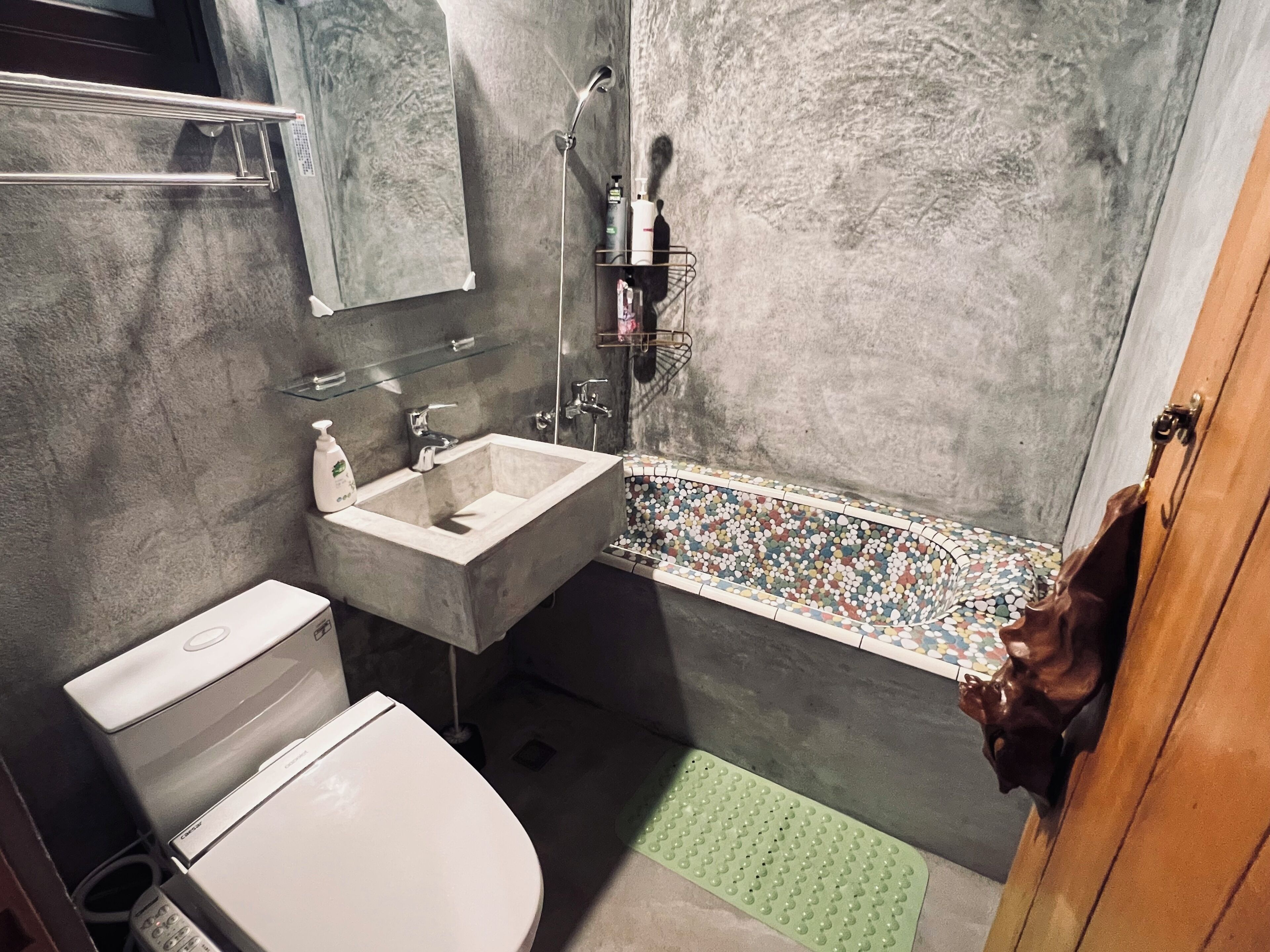Un baño con inodoro, lavamanos y ducha.