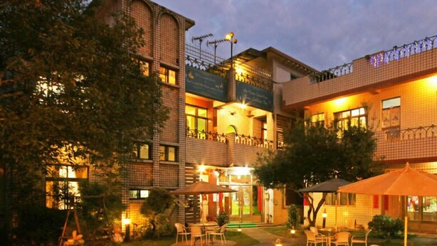 A hotel courtyard with outdoor seating, a slide, and a well-lit garden area. - Hua Shan Hor Yuan Homestay (Meishan)
