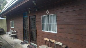 A wooden building with a covered patio area, a barred door, and a window with bars. - Hua Shan Hor Yuan Homestay (Meishan)