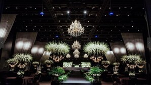 A formal event space with a central stage, chandeliers, and symmetrical floral arrangements. - Hotel ICC (Daejeon)