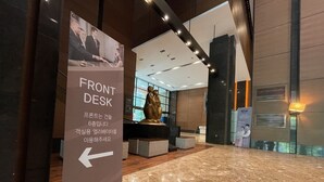 A hotel lobby with a marble floor, a reception desk, and a sign indicating the location of the front desk. - Hotel ICC (Daejeon)