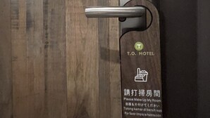 A hotel room door with a digital lock and a sign indicating the room number. - T.O Hotel Main Station (Taipei)