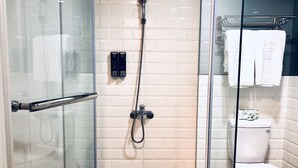 A modern bathroom with a glass shower enclosure, a toilet, and a glass door. - T.O Hotel Main Station (Taipei)