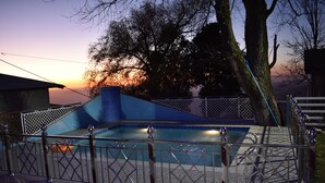 A swimming pool with a geometric design, surrounded by a metal fence with decorative elements. - Dream Land Hotel (Murree)