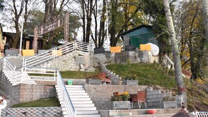 A staircase leading to a building with outdoor seating and a small structure nearby. - Dream Land Hotel (Murree)