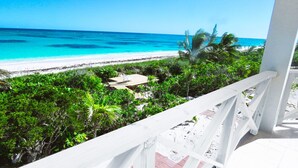 Een balkon met uitzicht op een strand en de oceaan.