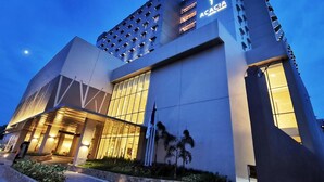 A modern building with a prominent 'ACACIA' sign, large windows, and a well-lit entrance area. - Acacia Hotel Davao (Davao)