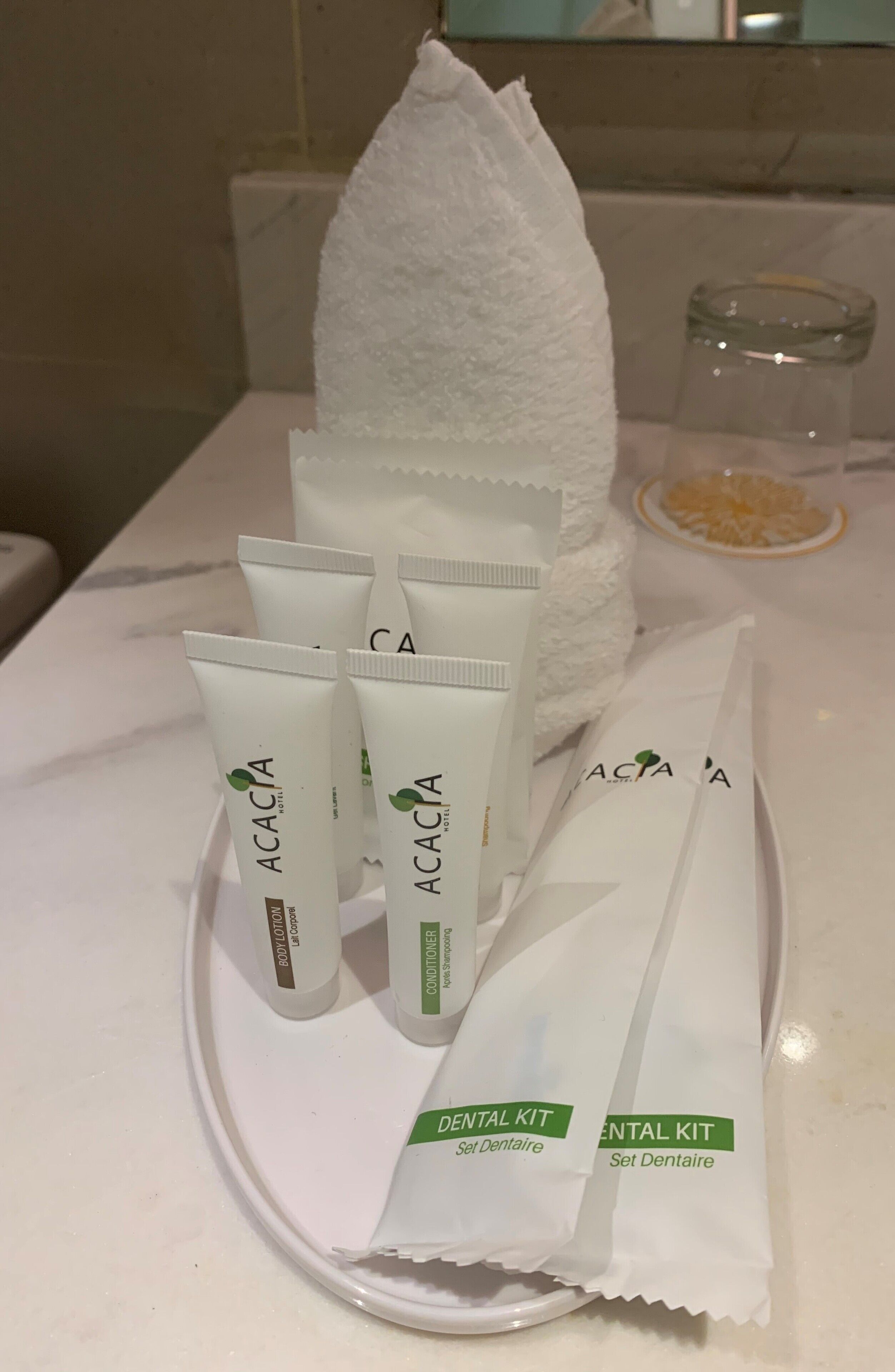 A dental care kit on a tray with four tubes and a towel.
