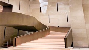 A modern interior with a curved staircase, a large chandelier, and a minimalist design. - Acacia Hotel Davao (Davao)