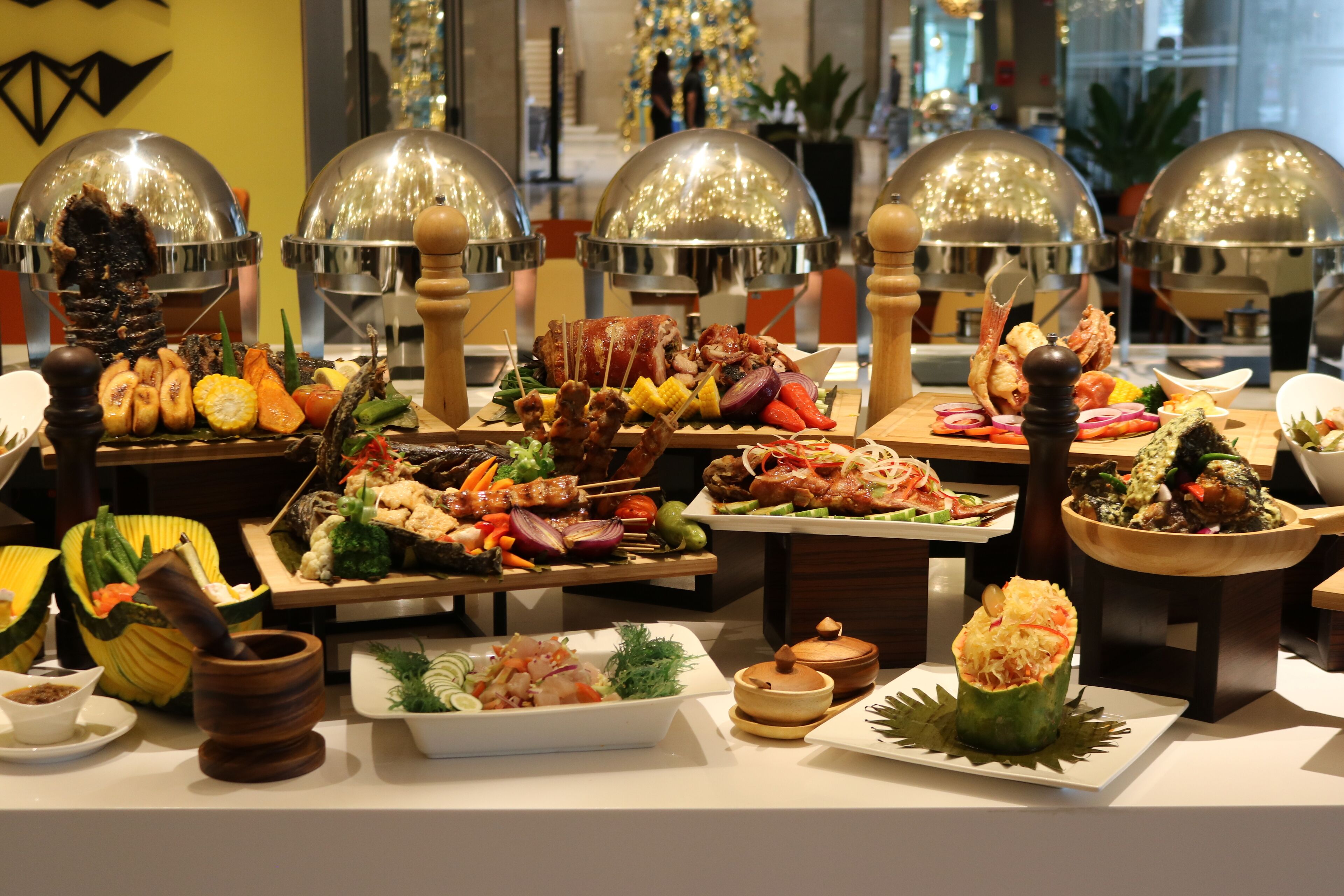 Un buffet proposant divers plats, avec un sapin de Noël en arrière-plan.