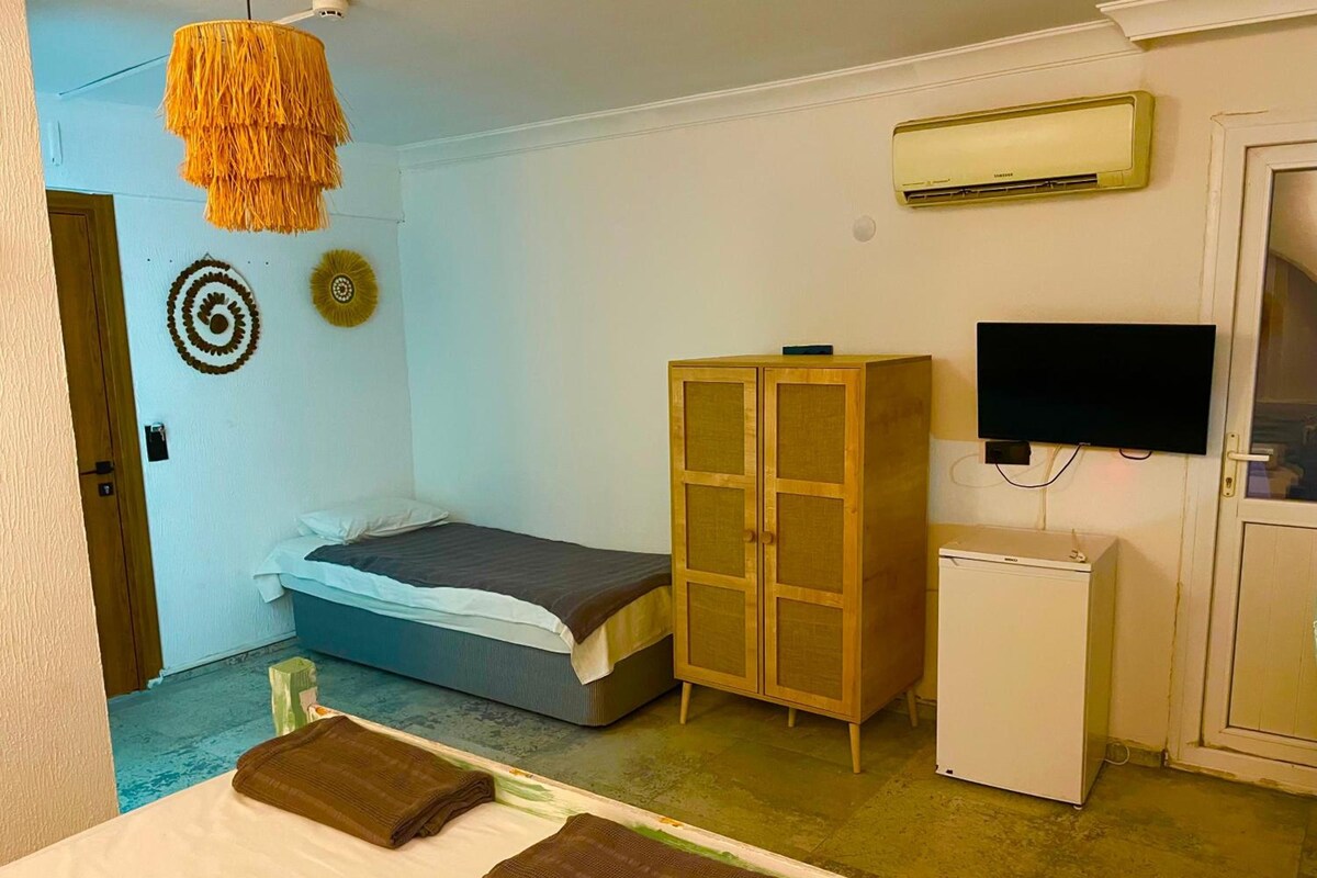 Quarto com cama, guarda-roupa, ar condicionado e televisão.
