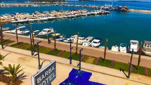 Un port de plaisance avec des bateaux amarrés, une enseigne d’hôtel et une vue dégagée sur l’eau.