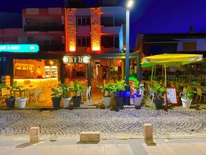 En bar med uteservering, en skylt med texten ”SAHIL 35 MARKET” och en byggnad med en balkong.