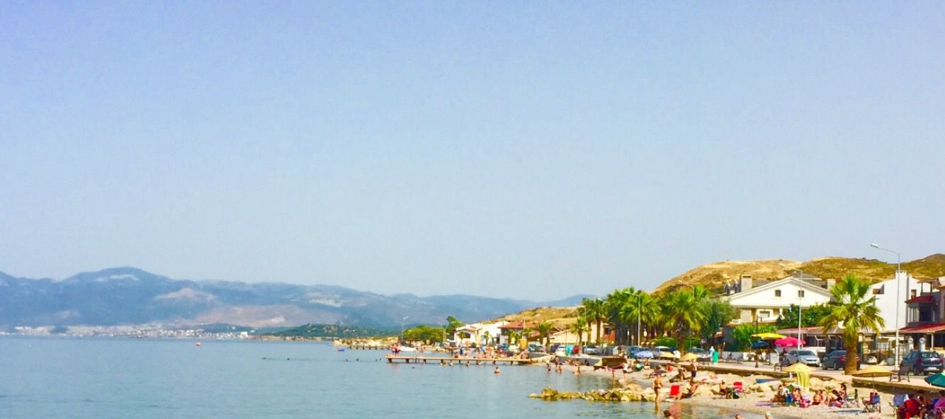 A beach scene with people swimming and sunbathing, and a sign indicating the beach is at 200 meters elevation.