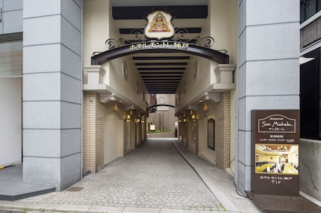 A hotel entrance with a stone pathway leading to a covered area.