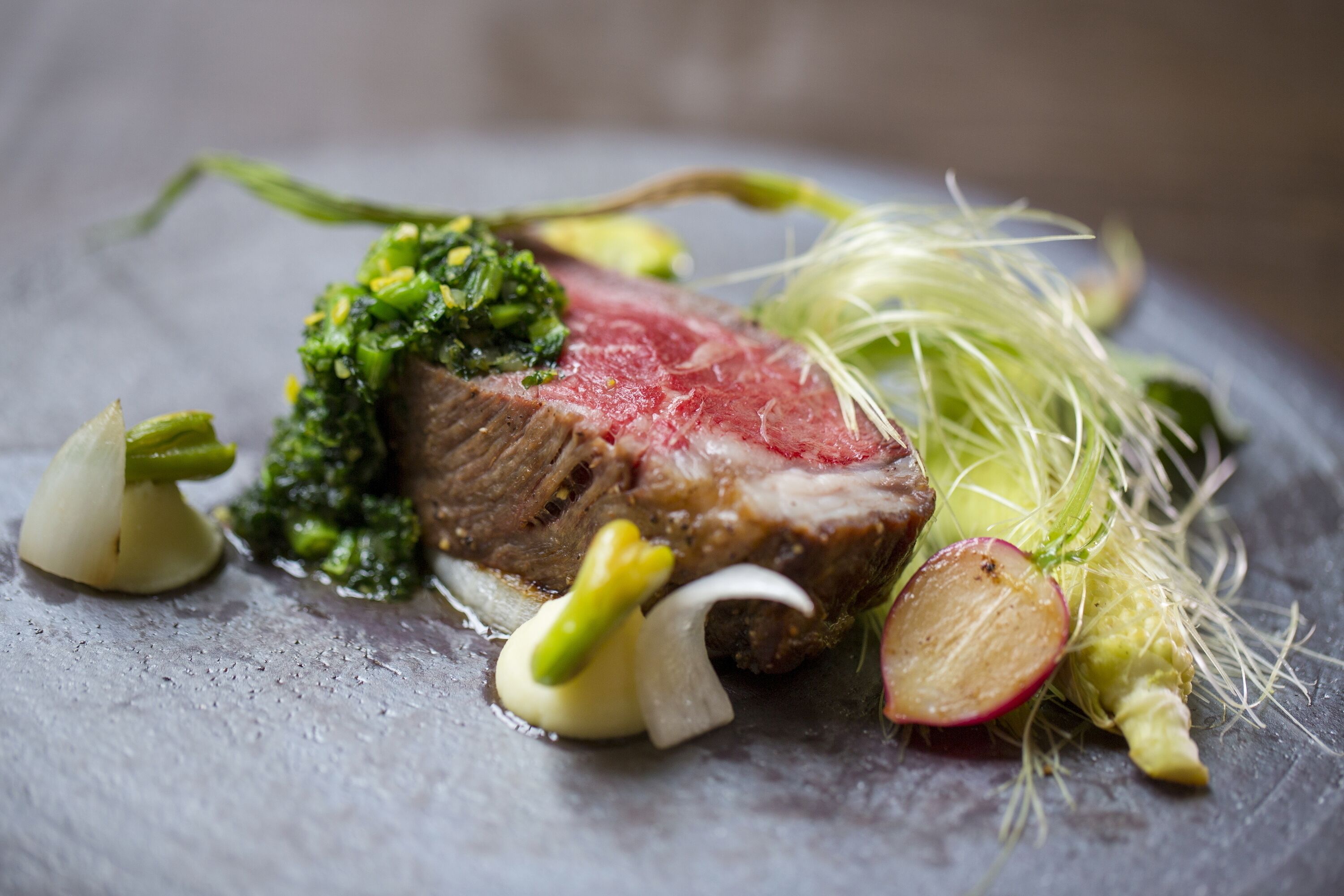 Un piatto con carne, verdure e ravanelli.