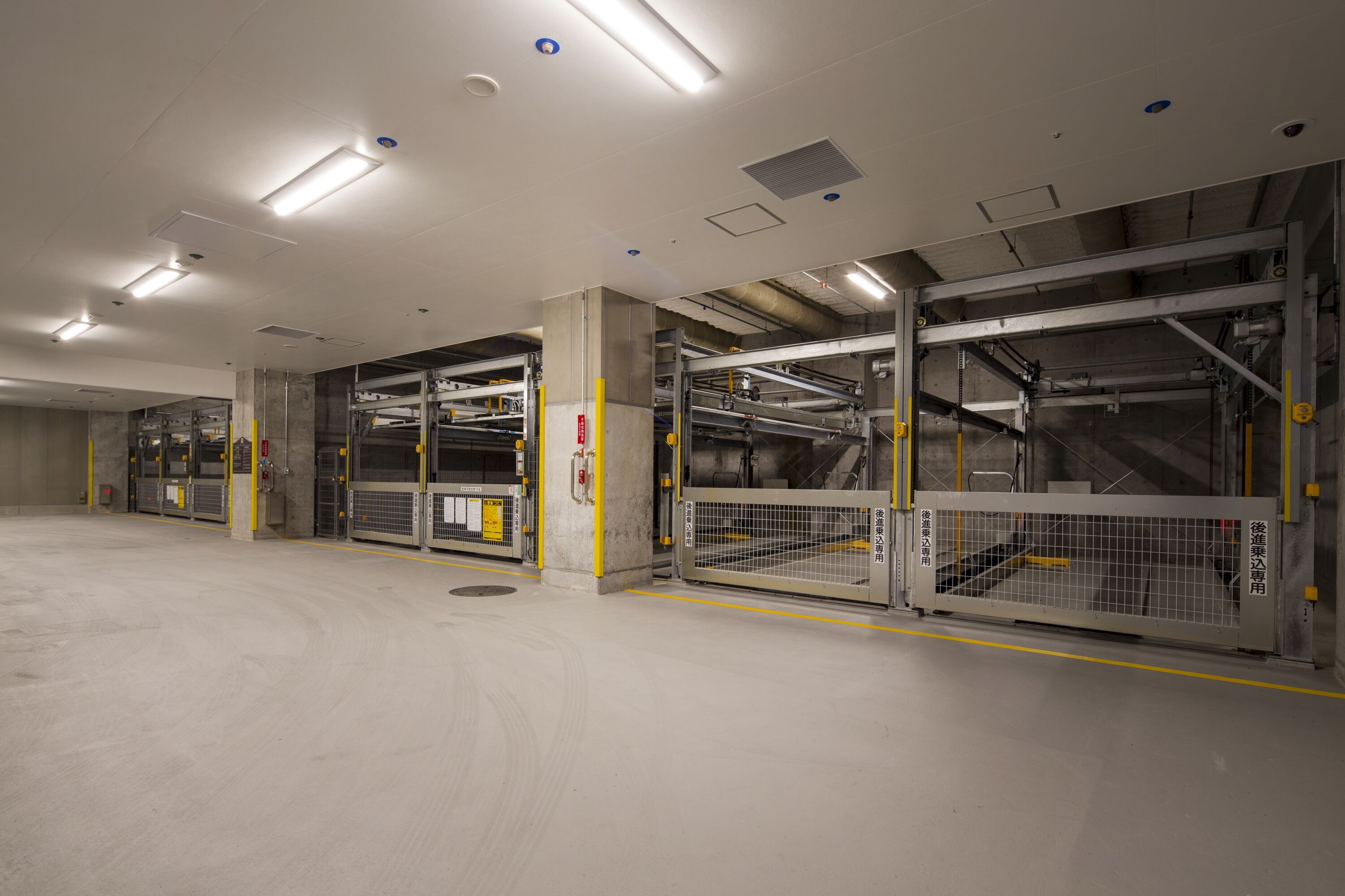 A spacious, modern indoor parking garage with multiple levels and clear signage.