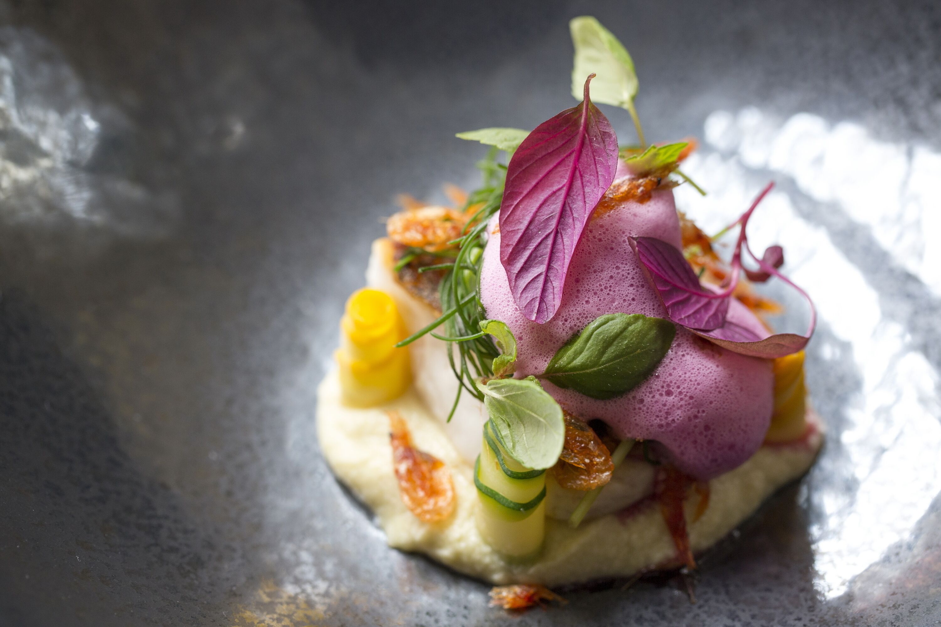 A dish with various ingredients and garnishes on a plate.