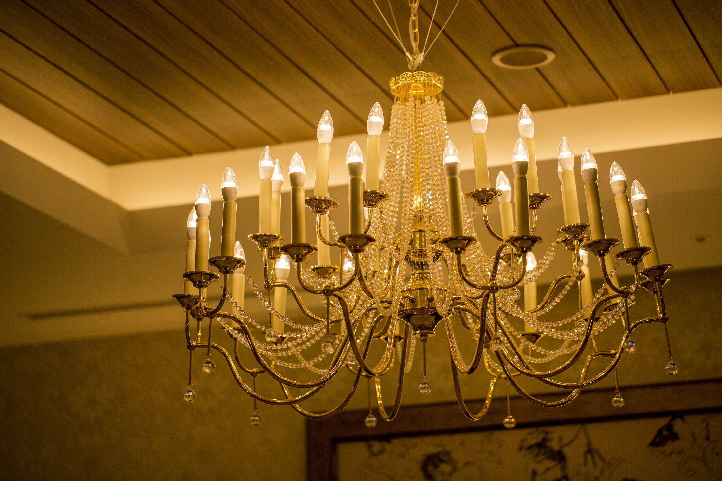 A chandelier with multiple candle-like lights and crystal decorations.
