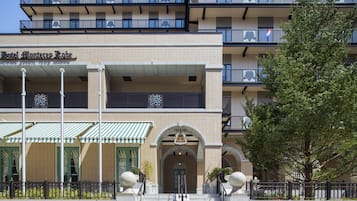 L'ingresso di un hotel con facciata in mattoni, tende verdi e un cartello con la scritta 'Hotel Monterey Place'.
