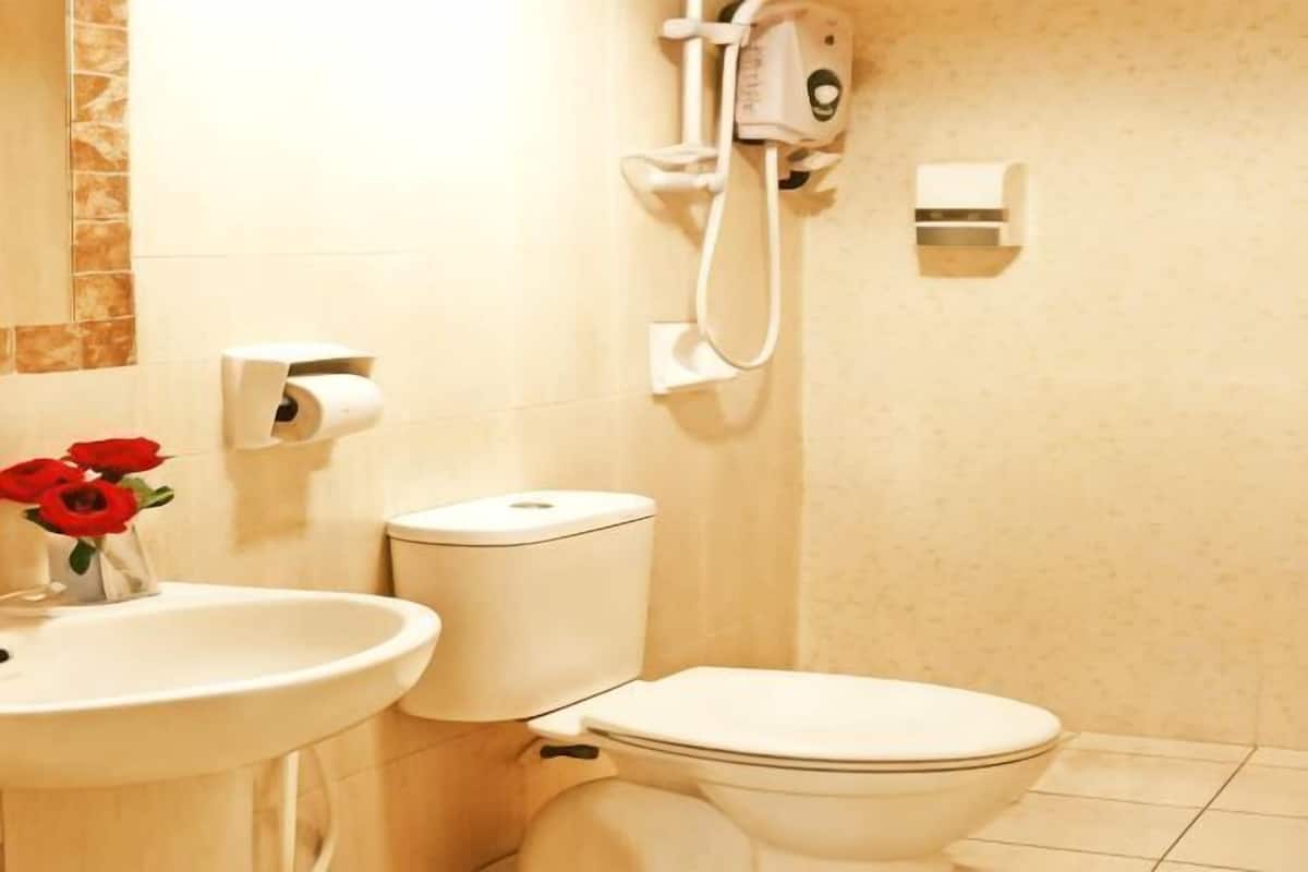 A bathroom with a toilet, sink, and shower.