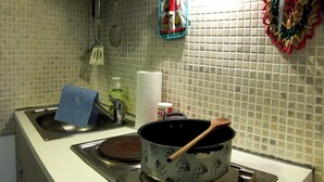 Une cuisine équipée d’une cuisinière, d’un évier et de divers ustensiles de cuisine.