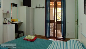 Une chambre avec un lit, un bureau, un mini-réfrigérateur et une télévision.