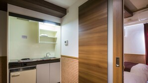 Una kitchenette compacta con pileta, cocina y alacenas.