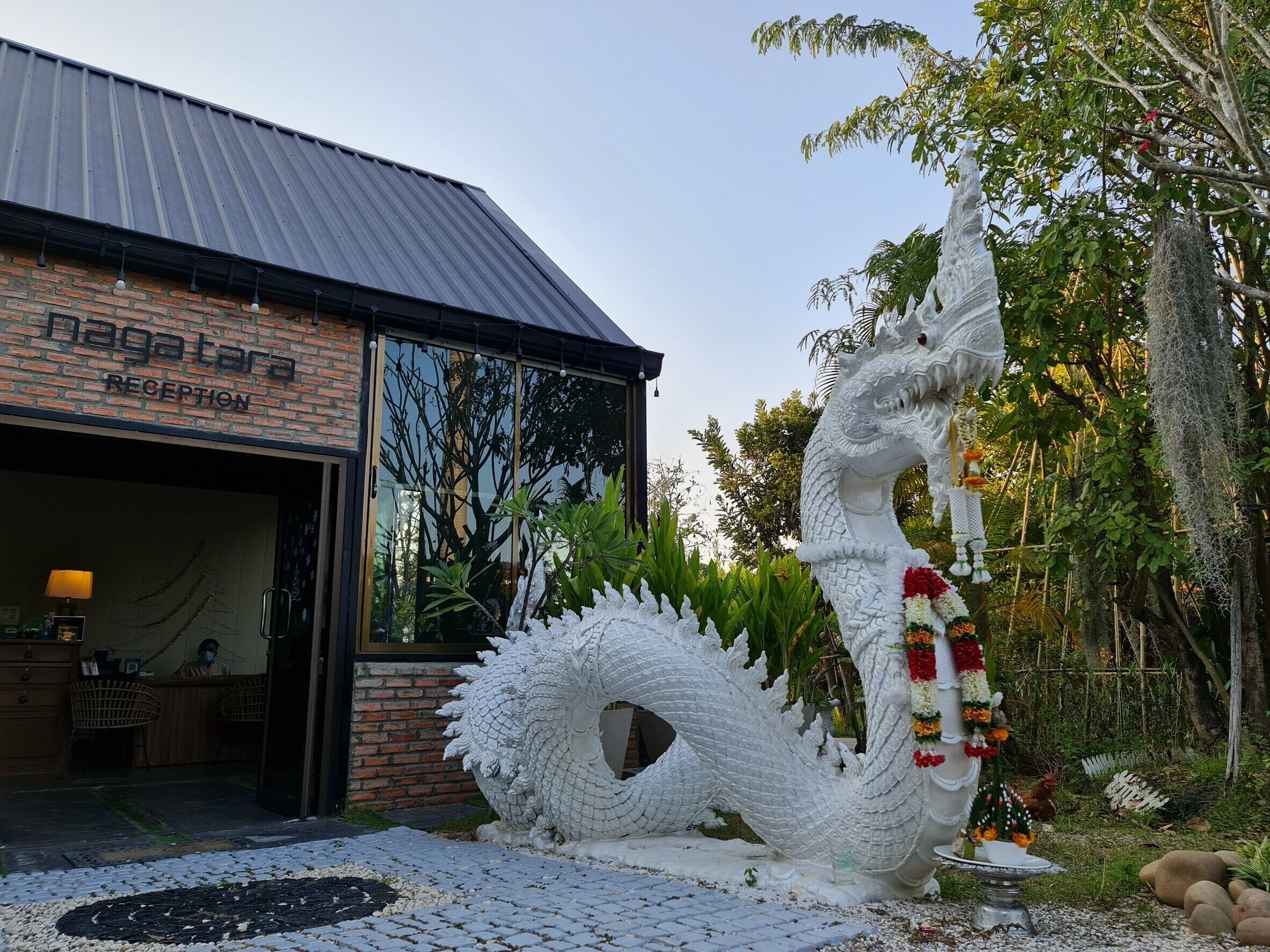 Zona de recepción con una gran escultura de dragón en el exterior.