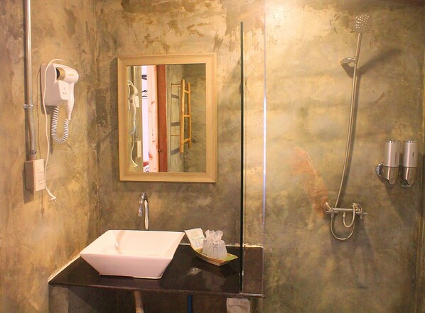A bathroom with a sink, a hairdryer, a mirror, and a shower. - Naga Tara Resort (Phayao)