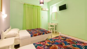 A room with two beds, a desk, a chair, a television, and an air conditioning unit. - Ni-Mar Studios & Apartments (Zakynthos)