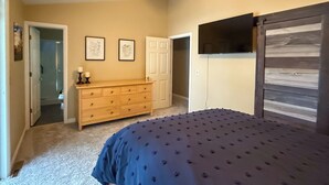 Un dormitorio con cama, cómoda y armario.