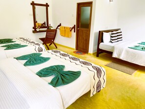 Une chambre d’hôtel avec deux lits, une chaise, un miroir et une porte.