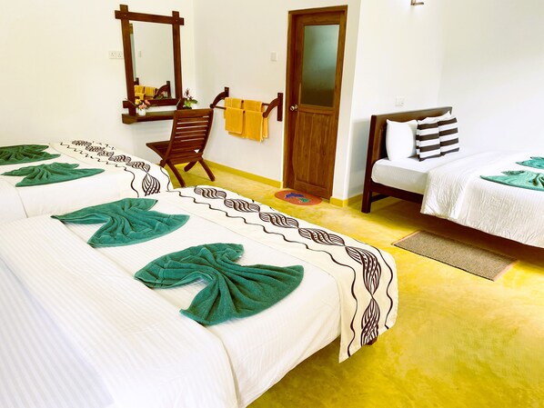 Una habitación de hotel con dos camas, una silla, un espejo y una puerta.