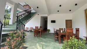 A spacious indoor area with a staircase, wooden furniture, and potted plants. - Misty Elegance Ella (Ella)