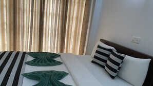 A neatly made bed with striped and solid pillows, a green towel, and a striped blanket. - Misty Elegance Ella (Ella)