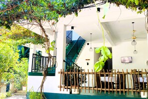 Una casa con escaleras, una planta colgante y una valla.