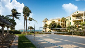A beachside hotel with a volleyball court, palm trees, and a view of the ocean. - Hyatt Windward Pointe 2 Bedroom (Key West)