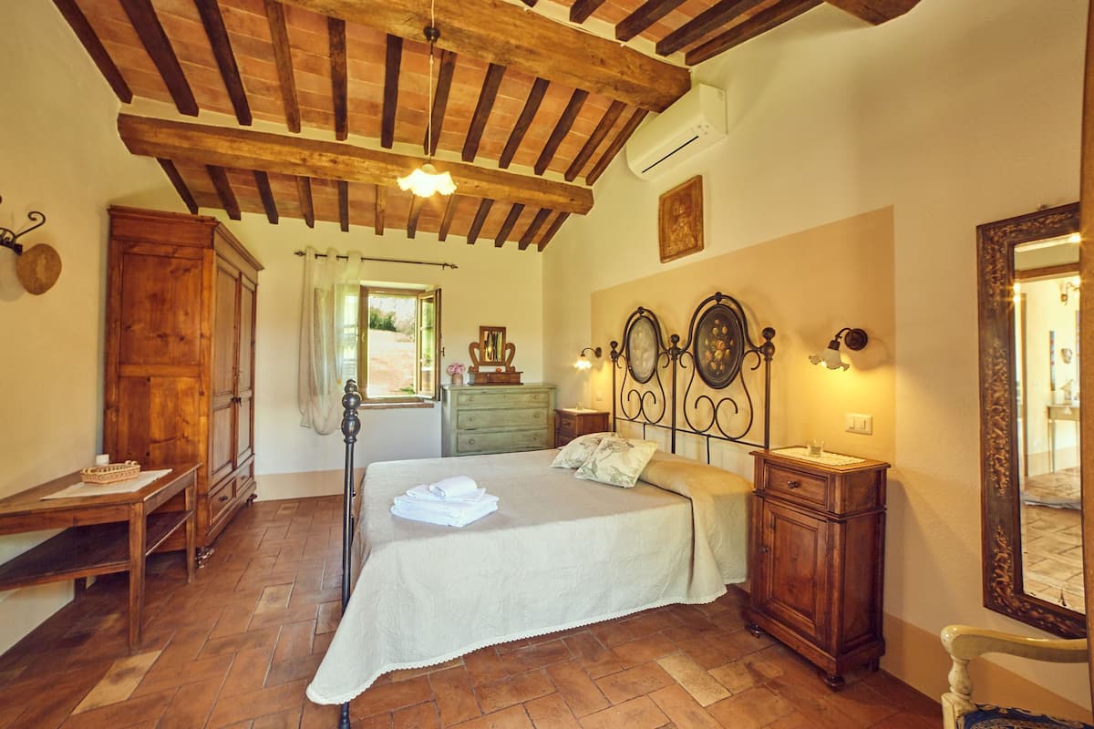 Un dormitorio con una cama grande, muebles de madera y un techo rústico.