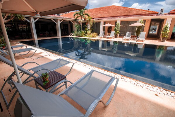 Alberca al aire libre y camastros 