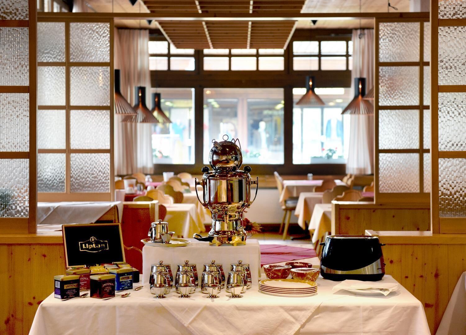 Un coin repas avec une grande table dressée pour un repas, agrémenté d’un trophée décoratif en guise de centre de table, de différents couverts et d’un assortiment de condiments.