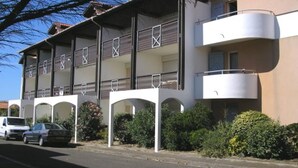 A multi-story building with balconies and a parking area. - Spacious Duplex for 6, 300m from Ocean, 2 Bedrooms, South Balcony (Biscarrosse Plage)
