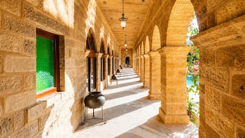Un passadís amb parets de pedra, portes d'arc i un penjoll.